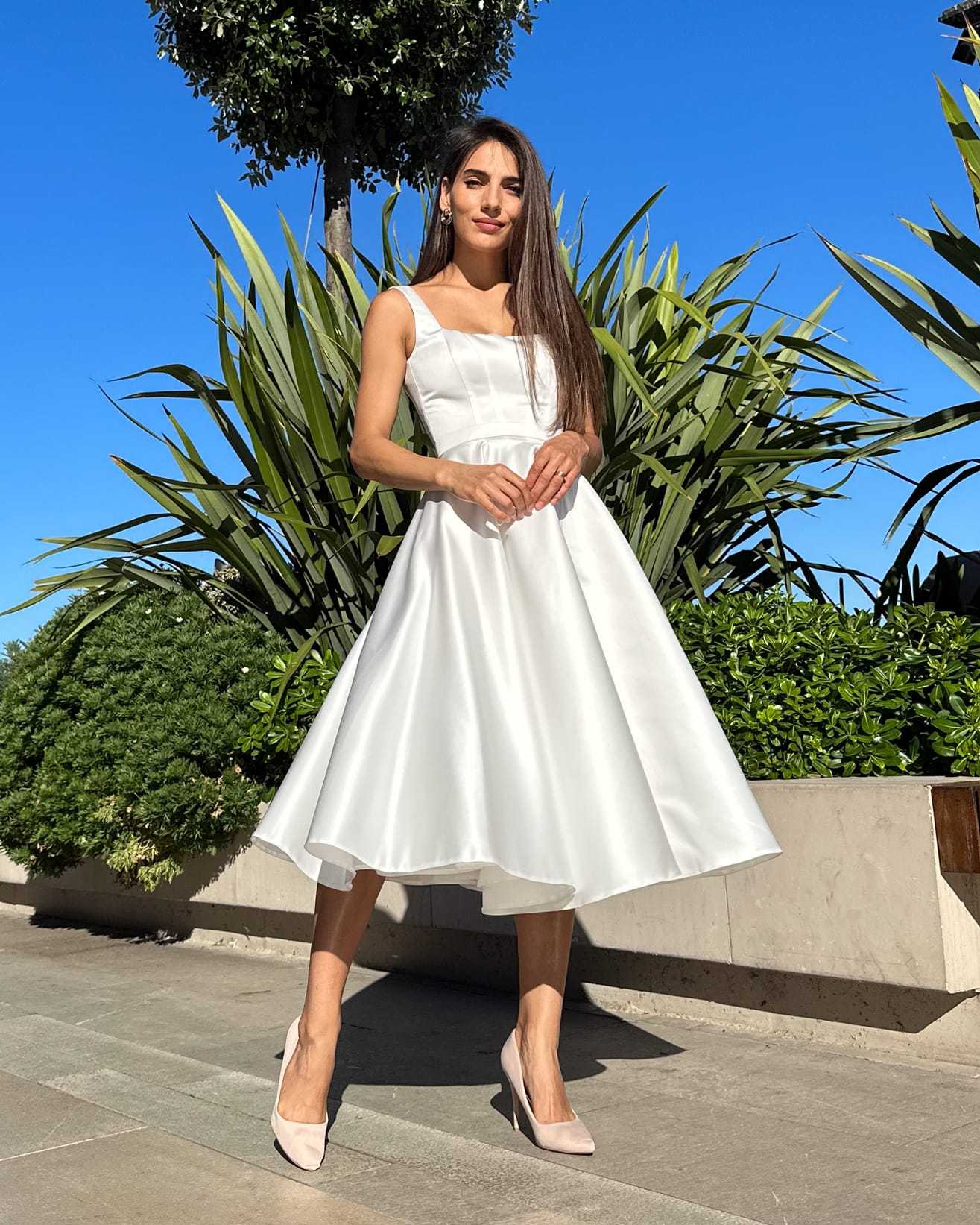 Rochie cununie civila midi albă cu slit și decolteu, croială A-line, din satin regal, pentru evenimente speciale.