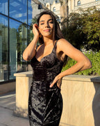 Rochie catifea neagra eleganta din catifea cu slit si decolteu, fotografie in exterior.