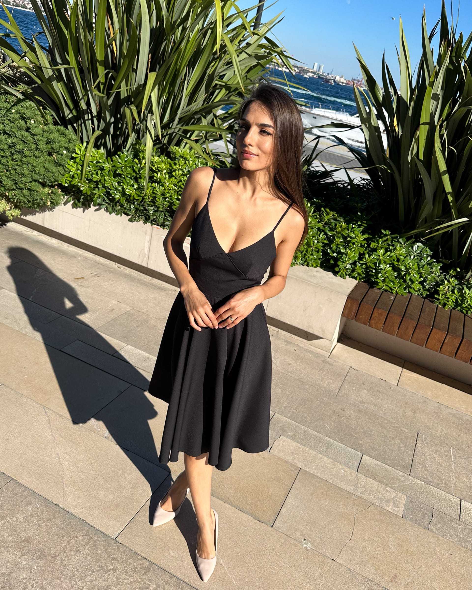 Rochie neagra elegantă scurtă cu bretele în grădină