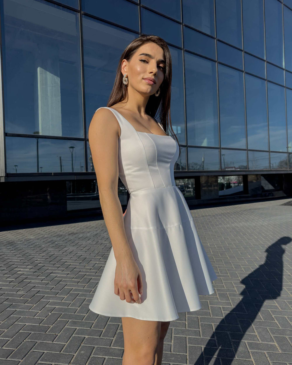 Rochie alba elegantă scurtă, ideală pentru evenimente speciale, cu decolteu delicat și fermoar la spate, oferind confort și stil.