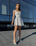 Rochie alba elegantă scurtă pentru evenimente speciale cu decolteu delicat și fermoar la spate.