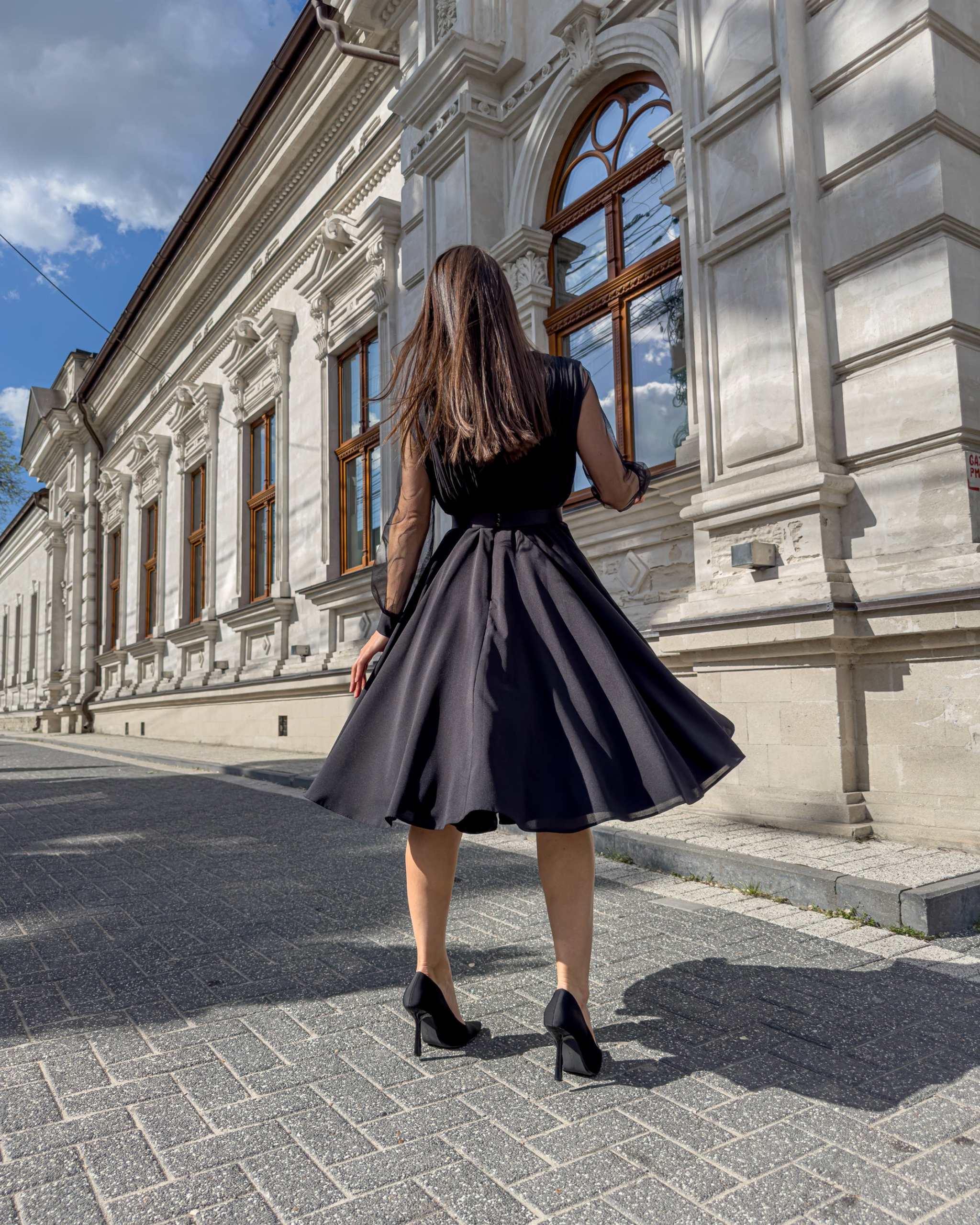 Rochie de ocazie neagră midi evazată cu mâneci lungi transparente și decolteu în V.