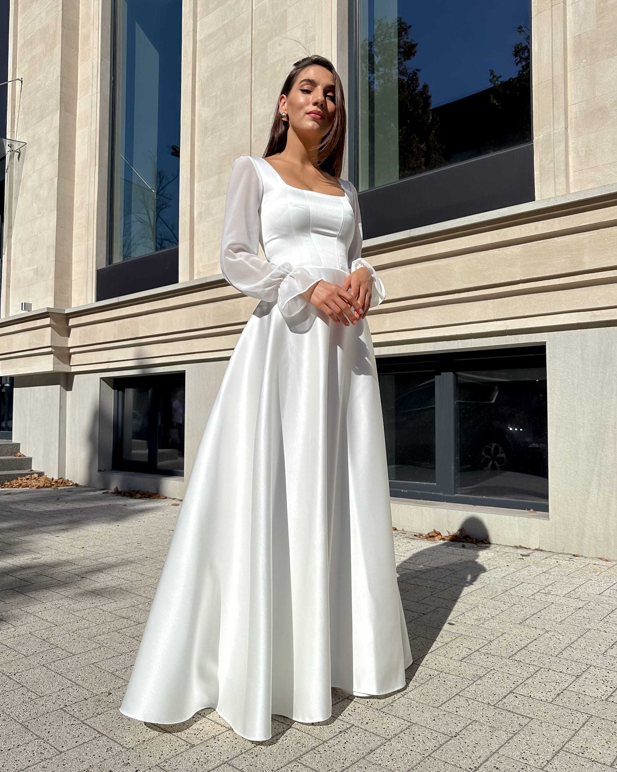 Rochie de mireasa lungă cu corset și mâneci semitransparente, perfectă pentru nuntă elegantă.