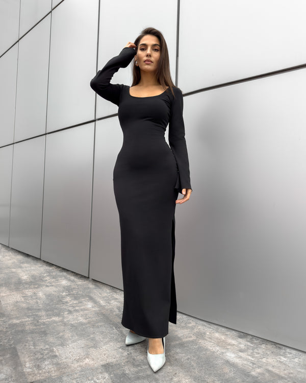 Rochie lunga mulată modelatoare cu mâneci lungi, confecționată din tricot elastic, evidențiind silueta elegantă.