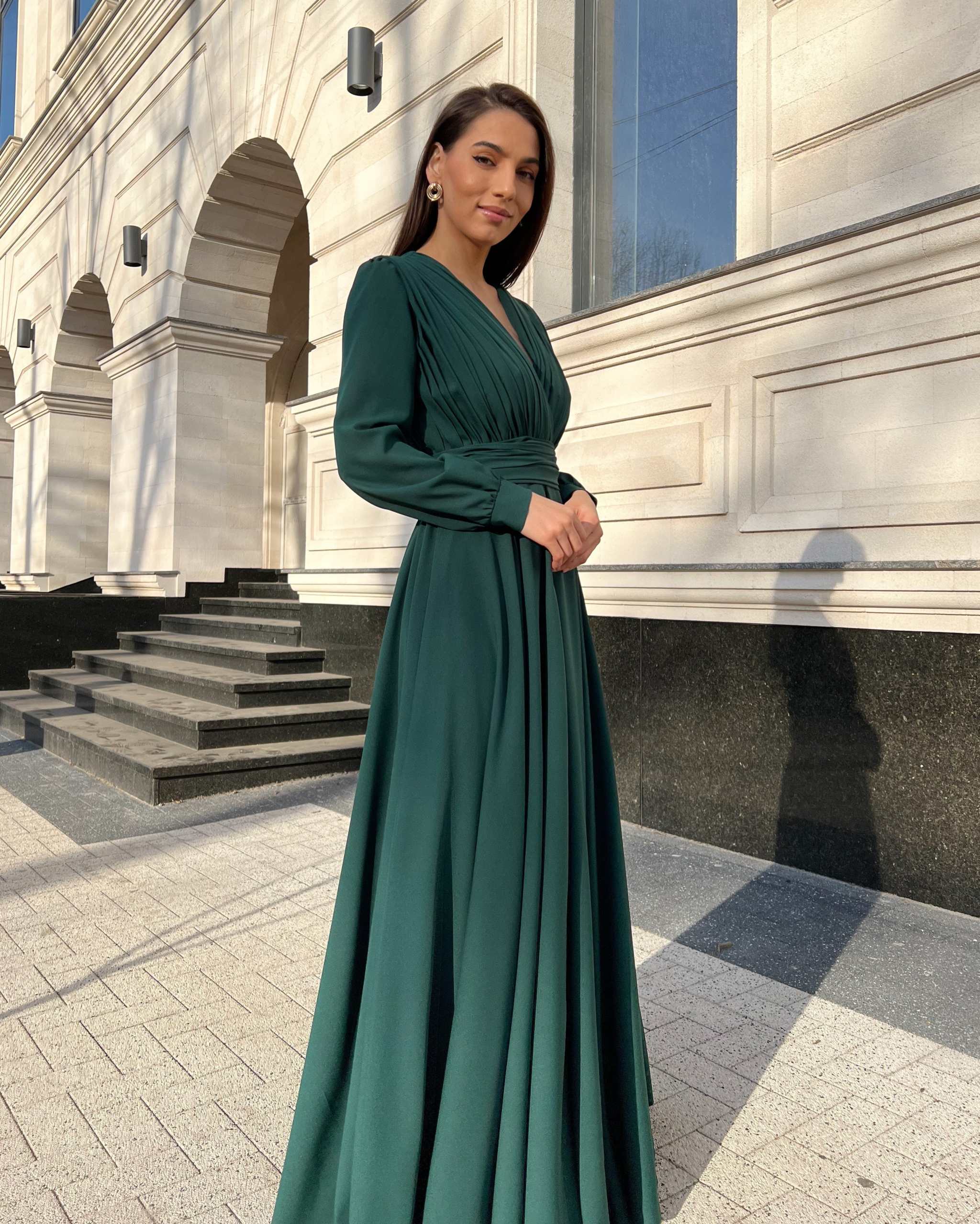 Rochie elegantă de seară verde, lungă, din voal, cu decolteu în V și mâneci cu nasturi.