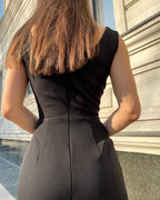 Rochie neagra cocktail fără mâneci cu șlit elegant pe piciorul stâng.
